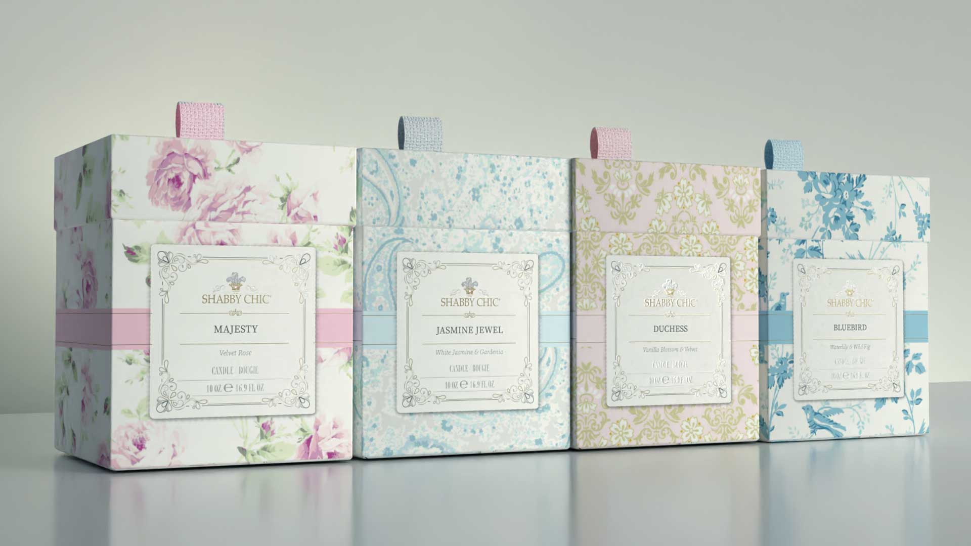 Shabby Chic candle boxes, angled — pattern and foil-label system across four scents